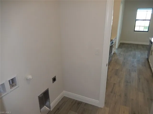Laundry room featuring dark wood-style floors, hookup for a washing machine, and hookup for an electric dryer