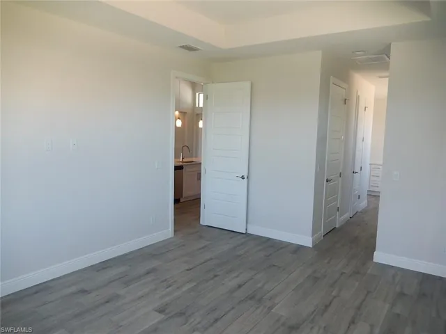Unfurnished bedroom with dark wood-style floors