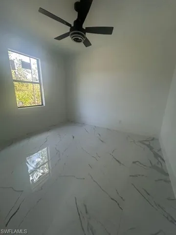 Spare room with marble finish flooring and ceiling fan
