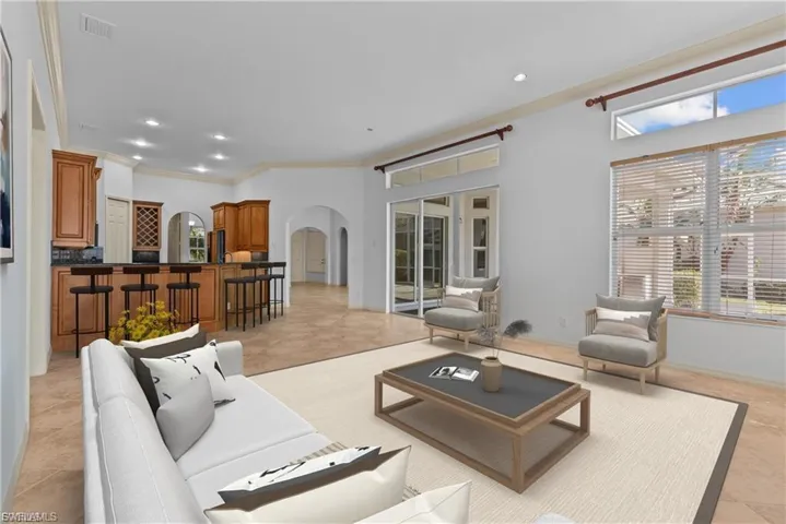Living room with arched walkways, ornamental molding, recessed lighting, and light tile patterned floors