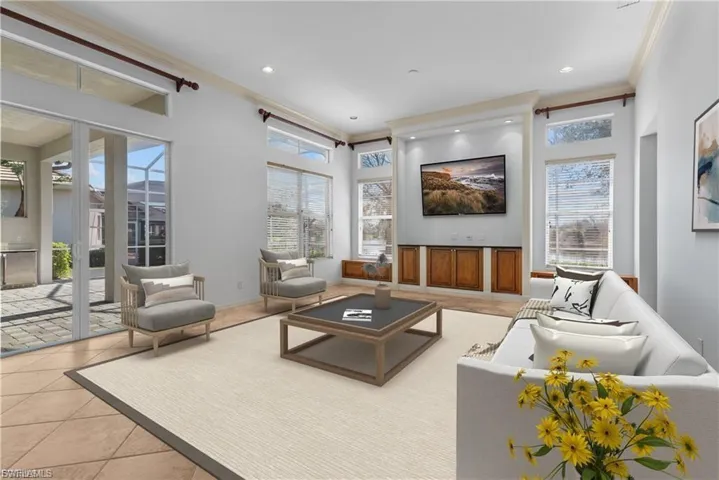 Living room with crown molding, light tile patterned flooring, healthy amount of natural light, and recessed lighting