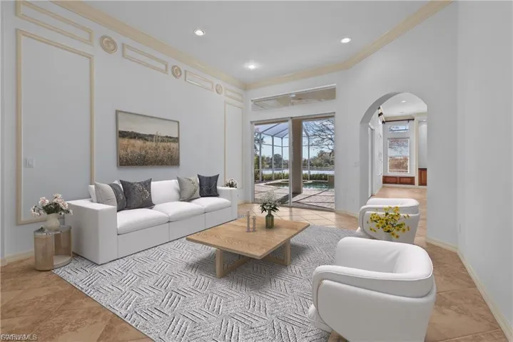 Living room featuring crown molding, arched walkways, recessed lighting, and light tile patterned floors