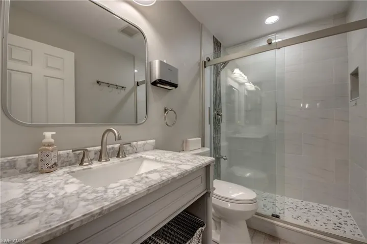 Full bath with a shower stall, vanity, and recessed lighting