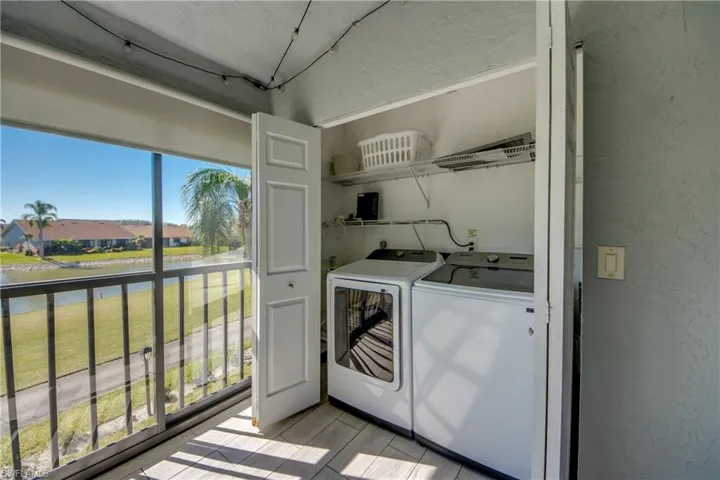 Washroom with a water view and washing machine and dryer