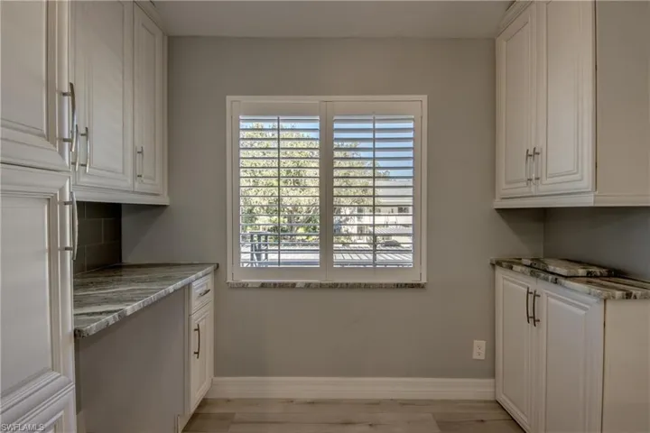 Laundry area featuring baseboards and light wood-style flooring