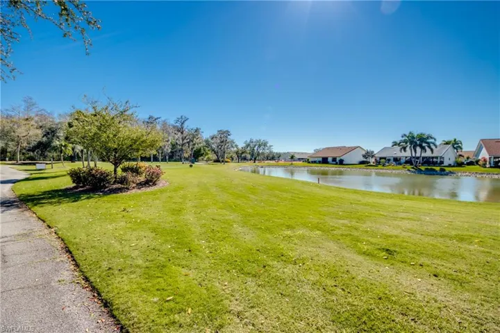 View of green lawn featuring a water view and a residential view