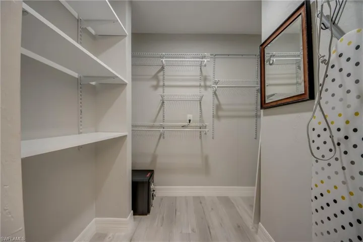 Walk in closet with light wood-type flooring