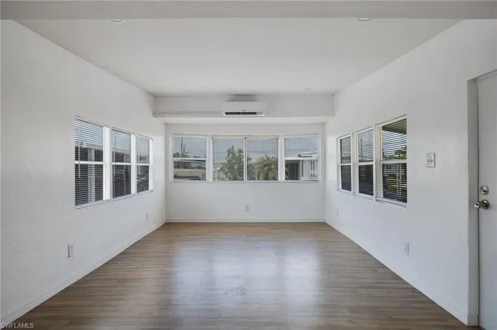 Unfurnished room with baseboards, a wall mounted AC