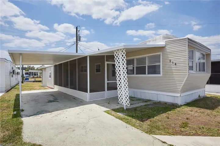Manufactured / mobile home featuring driveway, a sunroom, and an attached carport