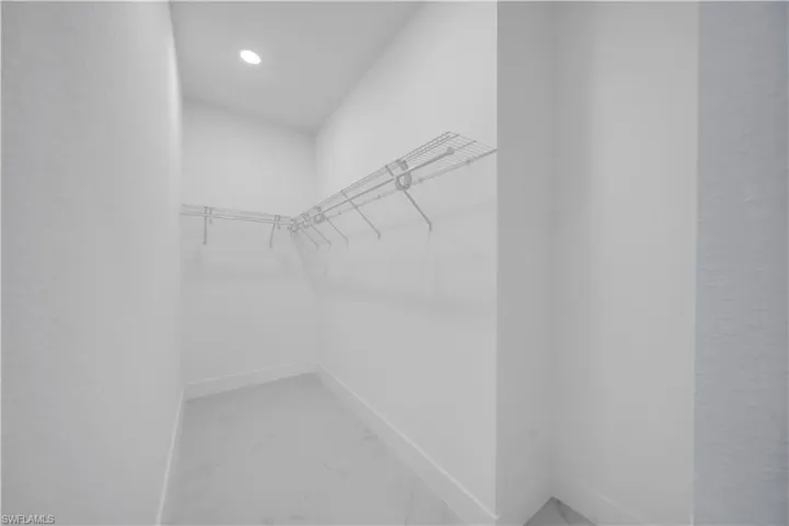 Walk-in closet featuring wire shelving, recessed lighting, and tile flooring