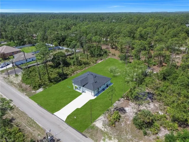 Contemporary single-story residence featuring a dark shingle roof and a concrete driveway