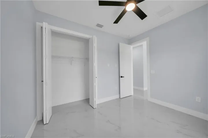 Room featuring light gray walls, white trim, and a ceiling fan with integrated lighting