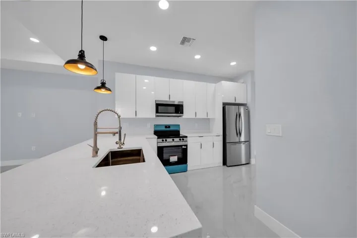 Contemporary kitchen featuring a large island with an undermount sink and gooseneck faucet