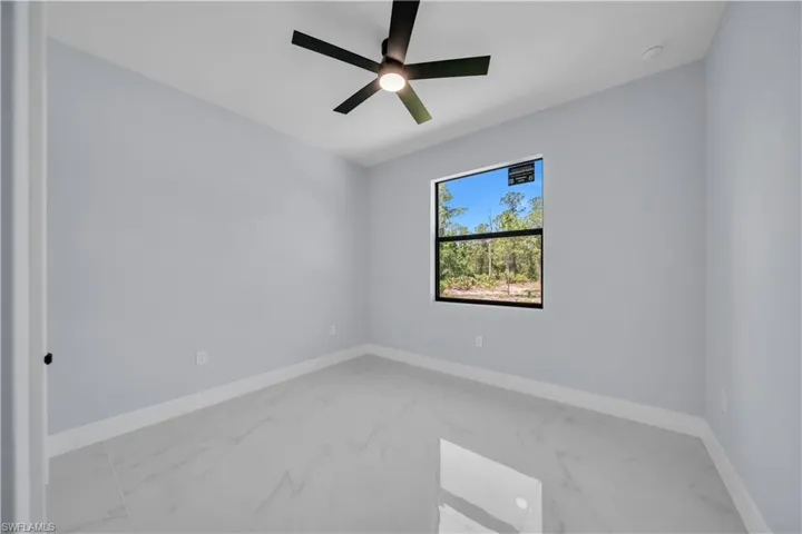 Room featuring light gray walls, white baseboards, and polished tile flooring