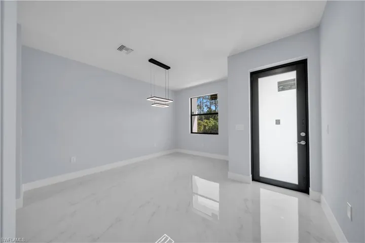 Entryway featuring light gray walls, white baseboards, and large format light-toned tile flooring