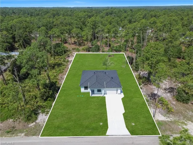 Newly constructed residence featuring a dark shingle roof, light-colored exterior, and an attached two-car garage