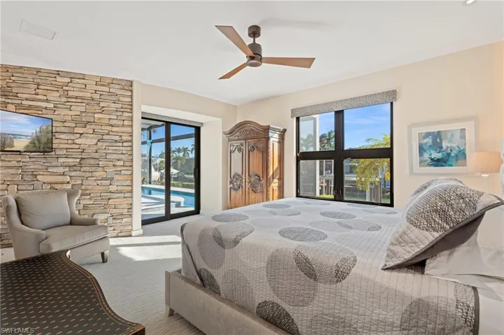 Carpeted bedroom featuring access to exterior, multiple windows, and ceiling fan