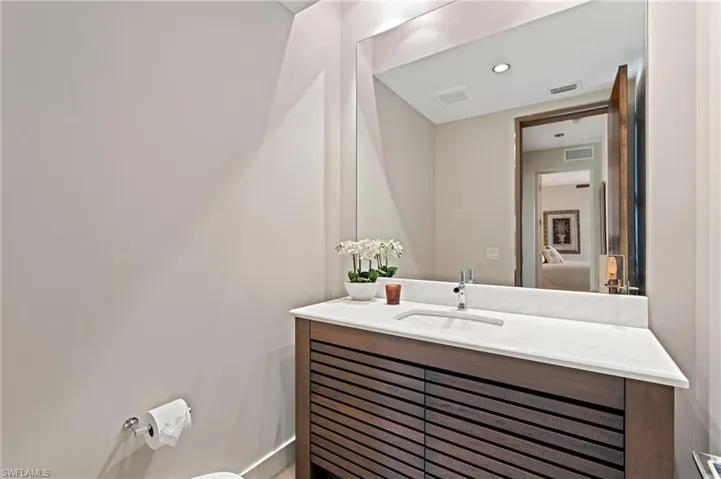 Half bathroom featuring vanity and toilet