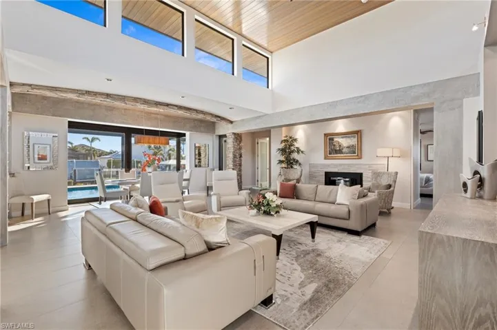 Living area featuring a towering ceiling and a glass covered fireplace