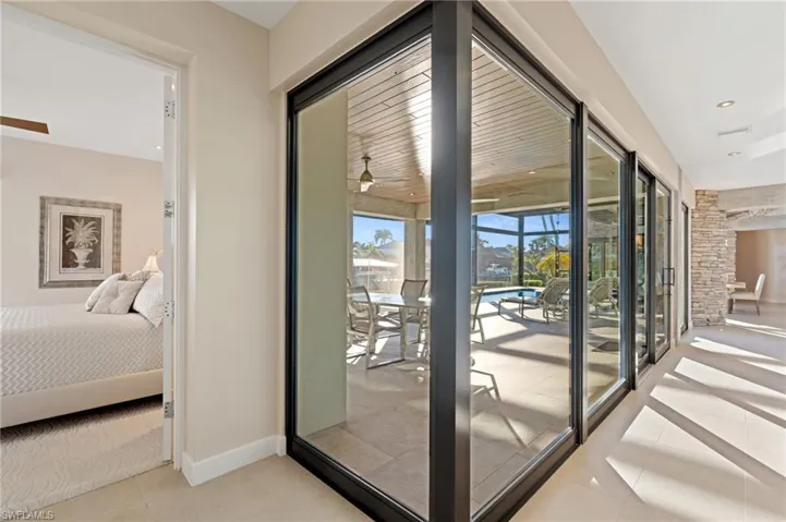 Doorway featuring light tile patterned floors and a ceiling fan