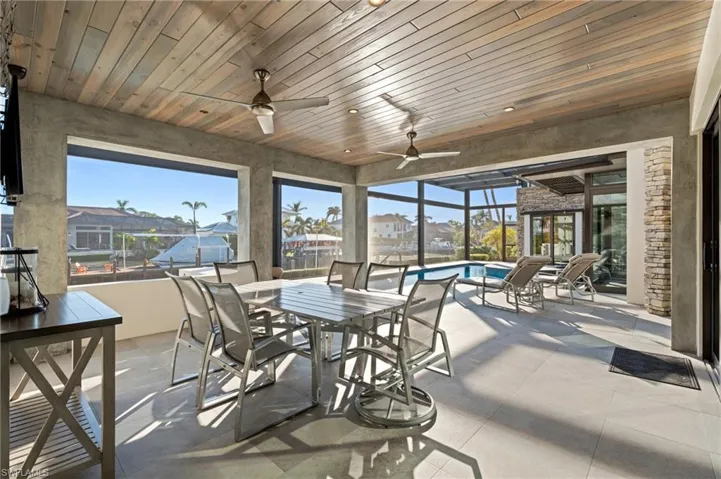 Sunroom featuring ceiling fan and a residential view