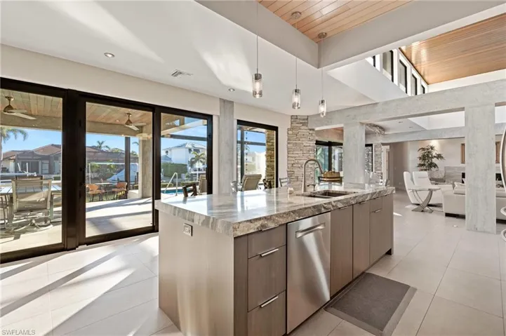 Kitchen featuring open floor plan, modern cabinets, light tile patterned flooring, stainless steel dishwasher, and wood ceiling