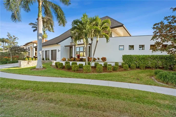 View of front facade with stucco siding, a front yard, and a garage