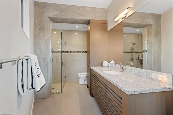 Full bath with vanity, a shower stall, and tile patterned flooring