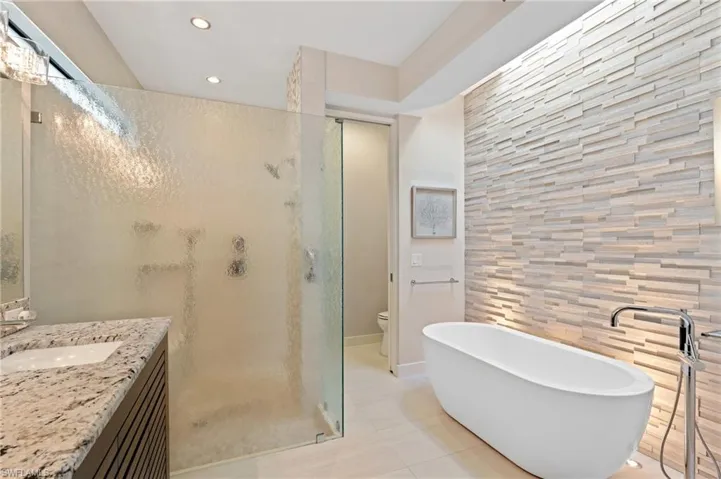 Bathroom with a shower stall, vanity, recessed lighting, a freestanding bath, and tile patterned floors