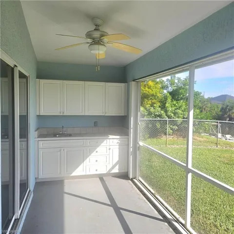 Unfurnished sunroom featuring a ceiling fan