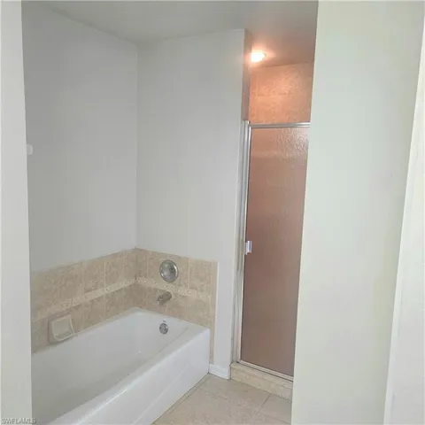 Full bath with a bath, a shower stall, and light tile patterned floors