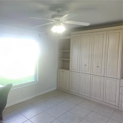 Unfurnished bedroom featuring a ceiling fan, a closet, and light tile patterned floors