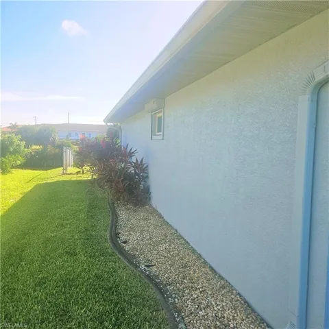 View of home's exterior with stucco siding and a lawn