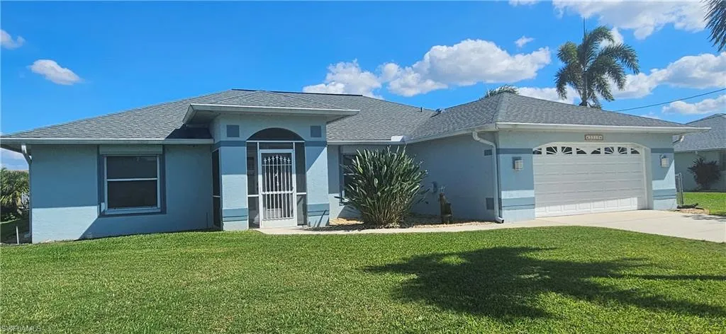 Single story home with an attached garage, a front yard, a shingled roof, and stucco siding