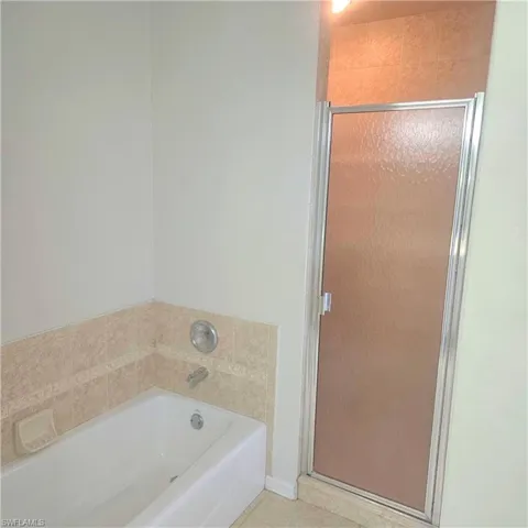 Bathroom featuring a bath and a stall shower