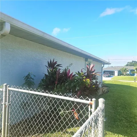 View of home's exterior with stucco siding and a gate