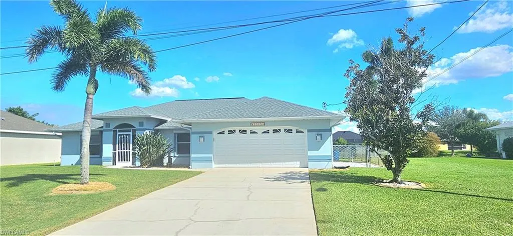 Single story home featuring stucco siding, an attached garage, a front lawn, driveway, and a shingled roof
