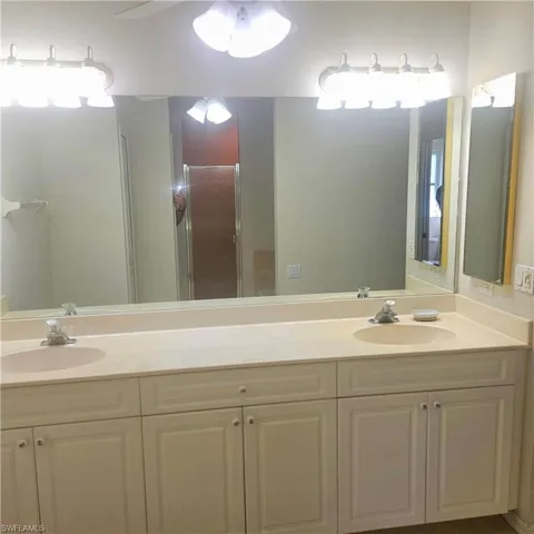 Bathroom featuring double vanity and a shower stall