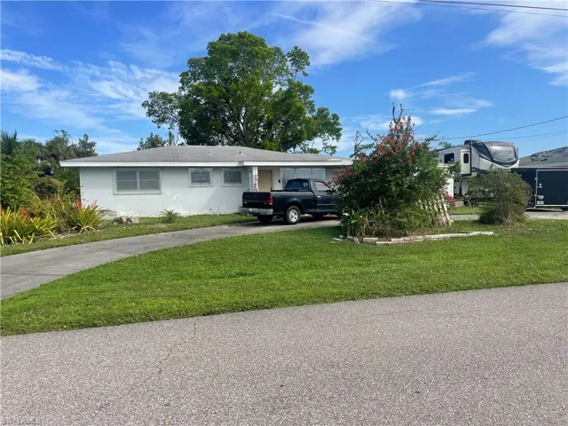 Single story home featuring a front lawn