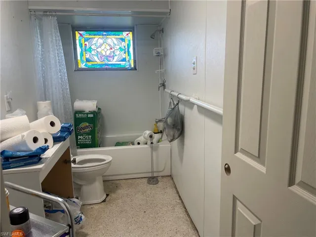 Full bathroom featuring shower / bath combo with shower curtain, vanity, and toilet