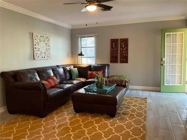 Living room featuring ceiling fan, ornamental molding, and hardwood / wood-style flooring