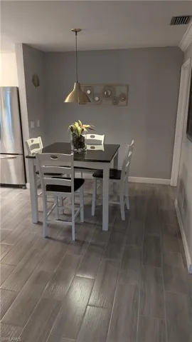 Dining space with dark hardwood / wood-style flooring