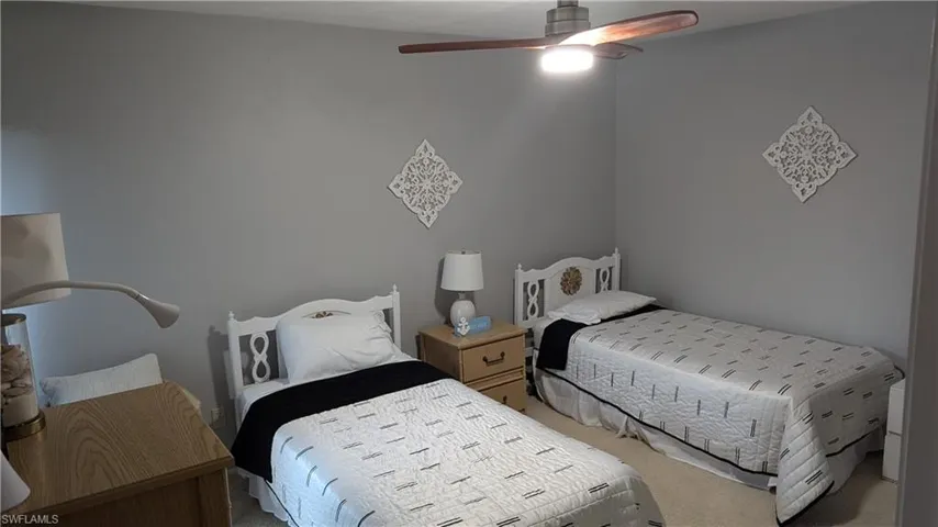 Bedroom with ceiling fan and light colored carpet