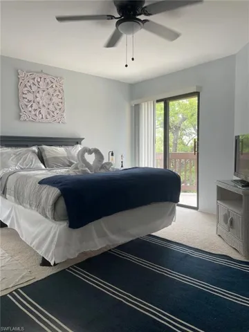Bedroom with access to exterior, ceiling fan, and carpet flooring