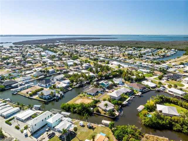 Aerial view of property and surrounding area with a nearby body of water and nearby suburban area