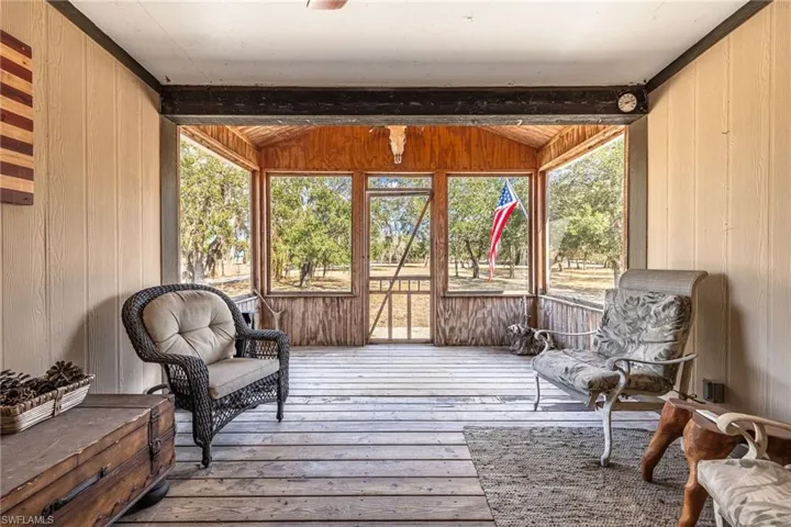 Sunroom with plenty of natural light, lofted ceiling, and a deck