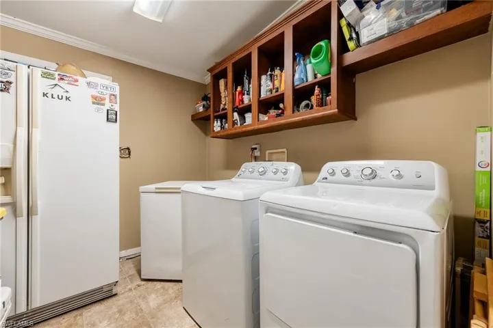 Laundry room with ornamental molding and washer and dryer