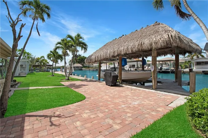 Dock area with a water view and a lawn