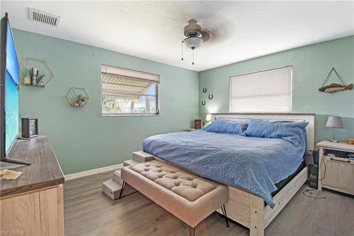 Bedroom with ceiling fan and hardwood / wood-style floors