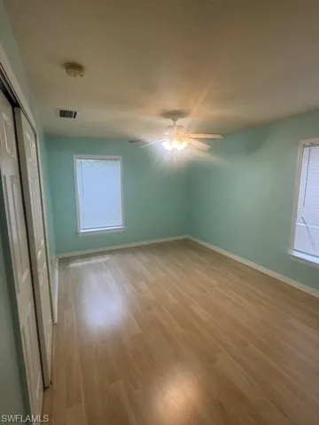 Unfurnished bedroom featuring light wood-style flooring, a closet, and ceiling fan